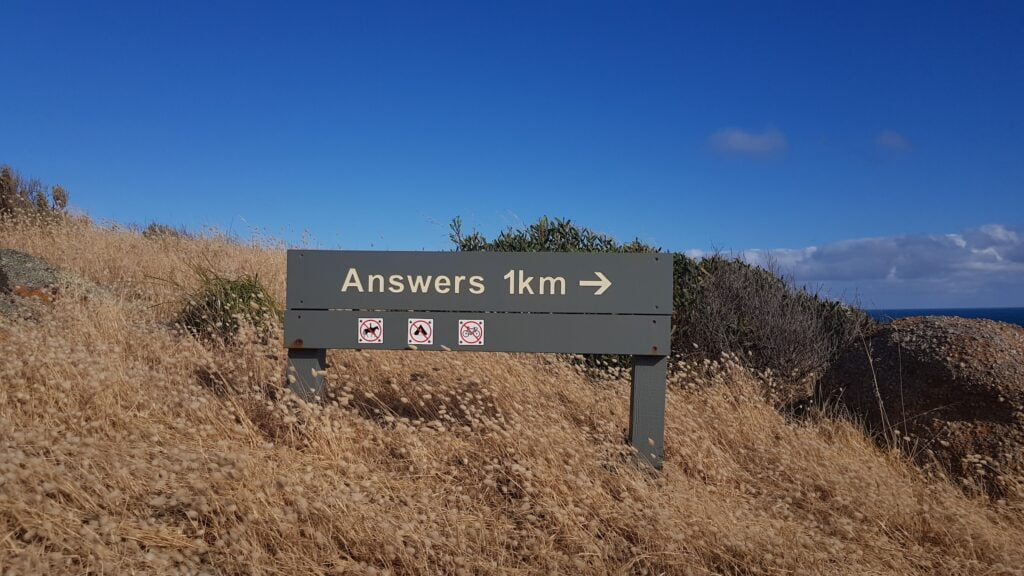 A sign stating 'Answers 1 km' on Granite Island, South Australia.